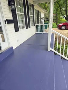 Exterior painting project showcasing a newly painted concrete porch floor and steps in a unique dark blue color.