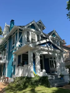 Freshly painted St. Louis Tudor-style home exterior featuring crisp white trim and bold teal accent by Malone Painting. Professional exterior painting enhances curb appeal, highlights architectural details, and protects historic homes from weather damage.